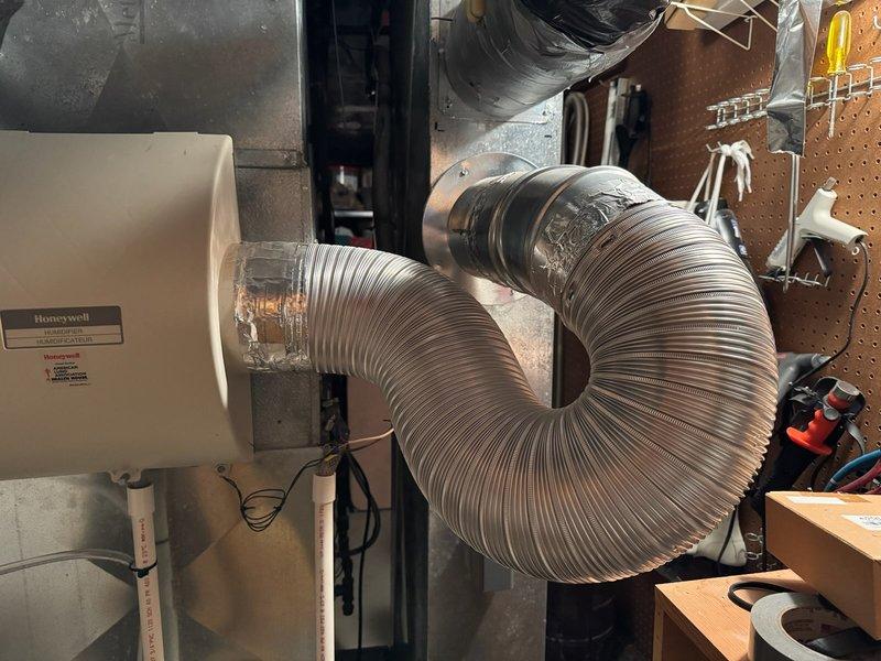 Responded to service call for homeowner requesting modification of vent pipe configuration from curved to 90-degree angle. Inspected 12-year-old furnace system located in basement, evaluated existing flexible ductwork, and assessed foam pipe insulation condition. Performed filter and humidifier component inspection to determine replacement part availability.