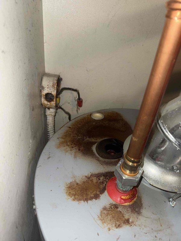 Responded to service call for reported furnace leak occurring since hot water tank installation. Diagnostic inspection revealed significant rust and corrosion at copper pipe connections on the 20+ year old furnace, with visible water staining on tank surfaces and connection points. Determined water heater flue connections were improperly sealed, causing condensation to accumulate and leak onto furnace components.