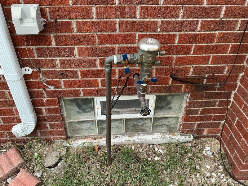 Responded to callback regarding AC condensate drain issue. Customer reported worsening bubbling at the bottom of the AC unit since recent furnace and AC installation. Inspected exterior plumbing components including pressure regulator valve and shutoff valves. Confirmed proper drainage system function and documented site conditions with photographs.