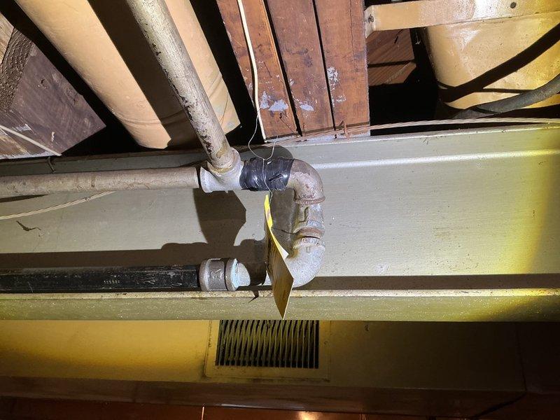Responded to DTE-reported gas leak at residence. Conducted comprehensive pressure test on gas supply system, focusing on aging metal pipes in basement utility area. Inspected all pipe joints and connections, particularly the L-shaped pipe assembly with greenish corrosion at connection points, confirming proper sealing and resolving the detected gas leak.