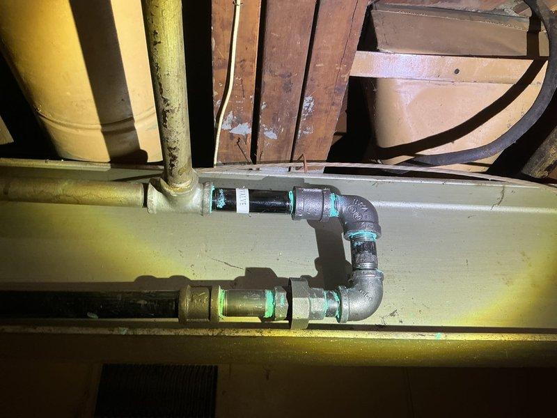 Responded to DTE-reported gas leak at residence. Conducted comprehensive pressure test on gas supply system, focusing on aging metal pipes in basement utility area. Inspected all pipe joints and connections, particularly the L-shaped pipe assembly with greenish corrosion at connection points, confirming proper sealing and resolving the detected gas leak.