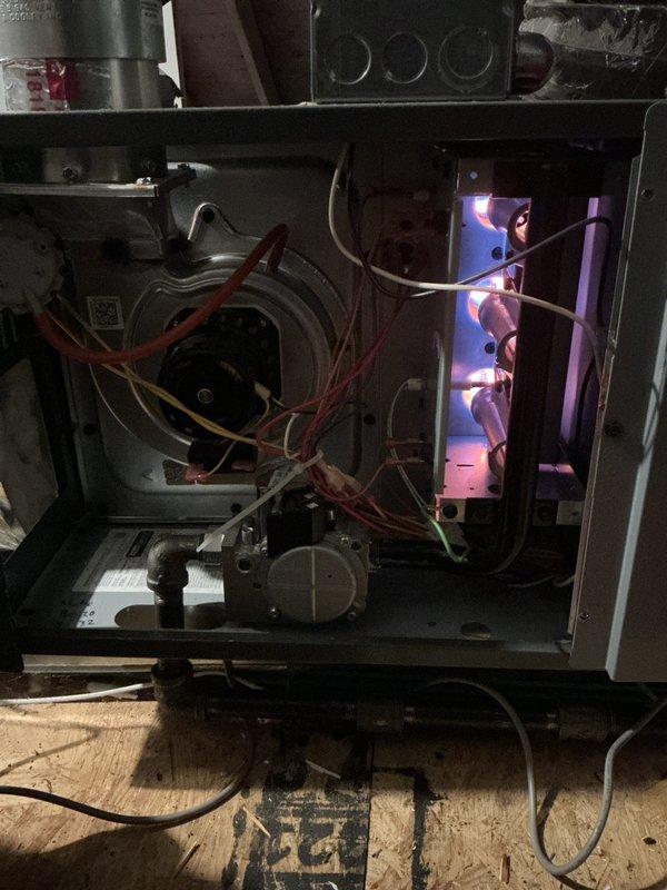 Performed comprehensive tune-up on dual HVAC system with units located in attic and basement. Inspected furnace operation, observing proper flame pattern in gas burner assembly (3 burners with consistent blue flames) and checked electrical components including blower motor assembly and wiring connections. Noted system was operational but recommended regular cleaning due to visible dust accumulation on internal components.