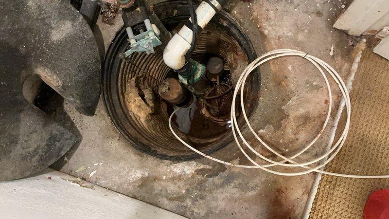 Diagnosed and replaced malfunctioning primary sump pump system that was causing backup pump activation. Observed significant mineral buildup and corrosion on pump components with sediment accumulation in basin. Additionally, repaired stuck faucet handle and addressed leaking toilet issue during service call.