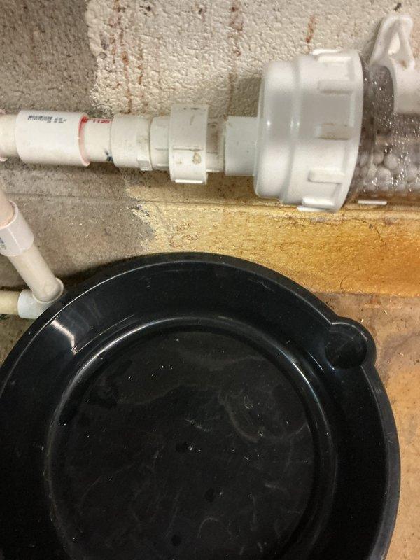 Responded to water leak issue with Navien combi unit. Identified active leak at PVC pipe connection in mechanical room, with standing water and staining visible on concrete floor. Diagnosed and repaired faulty connection in the condensate drainage system where moisture was visibly accumulating.