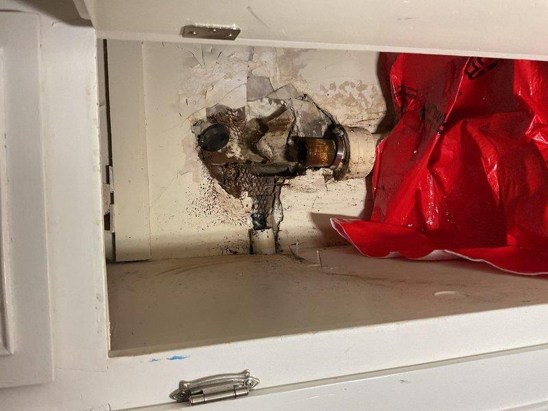 Performed main drain cleanout requiring K1500 heavy-duty equipment due to severe blockage. Inspection revealed significant water damage and mold growth around pipe connections in the utility cabinet, with deterioration of surrounding wall materials. The PVC P-trap configuration showed deterioration at joints, indicating ongoing moisture issues that were addressed during service.