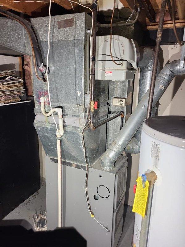 Conducted a comprehensive evaluation of the existing HVAC system, including an aging furnace unit with visible dust accumulation and an outdoor condensing unit mounted on a concrete pad. Assessment focused on full system replacement options with particular attention to the customer's primary concern of replacing the air conditioning component, while also providing alternative scenarios that include furnace replacement for a complete system upgrade.