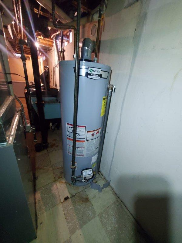 # HVAC Service Report - Furnace Repair

Responded to service call for furnace failure with no heat condition. Upon arrival, observed pressure switch sensor fault indicated by flashing diagnostic light on control board. Performed system diagnostics and confirmed control board malfunction preventing ignition sequence. Documented existing equipment configuration including water heater and furnace installation in mechanical room with photos of failed control board showing multiple relays and electronic components. Replacement control board was retrieved from shop inventory and installed to restore furnace operation and resolve no-heat condition.