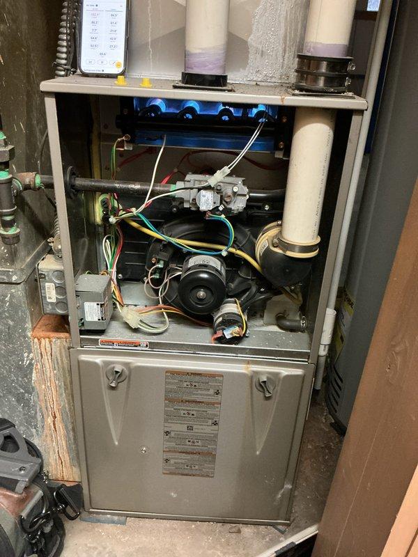 # HVAC Service Report - Furnace Repair

Responded to service call for non-operational furnace with manual fan function only. Upon arrival, performed systematic diagnostic evaluation of heating system. Removed front access panel to inspect internal components and electrical systems.

Conducted voltage testing using digital multimeter to assess power supply and control circuit functionality. Measured 93.4V at critical connection points to identify electrical irregularities affecting ignition sequence. Inspected gas valve assembly, blower motor, and associated wiring harnesses for proper connections and component integrity.

Evaluated control board signals, safety switches, and thermostat communication pathways. Examined flame sensor, ignitor assembly, and limit switches as potential failure points preventing furnace operation. Verified proper grounding and traced colored wire connections (yellow, red, blue, green) through control circuits to isolate malfunction.

Tested blower motor oper
