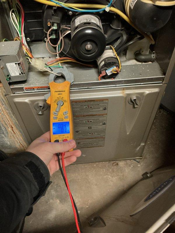 # HVAC Service Report - Furnace Repair

Responded to service call for non-operational furnace with manual fan function only. Upon arrival, performed systematic diagnostic evaluation of heating system. Removed front access panel to inspect internal components and electrical systems.

Conducted voltage testing using digital multimeter to assess power supply and control circuit functionality. Measured 93.4V at critical connection points to identify electrical irregularities affecting ignition sequence. Inspected gas valve assembly, blower motor, and associated wiring harnesses for proper connections and component integrity.

Evaluated control board signals, safety switches, and thermostat communication pathways. Examined flame sensor, ignitor assembly, and limit switches as potential failure points preventing furnace operation. Verified proper grounding and traced colored wire connections (yellow, red, blue, green) through control circuits to isolate malfunction.

Tested blower motor oper