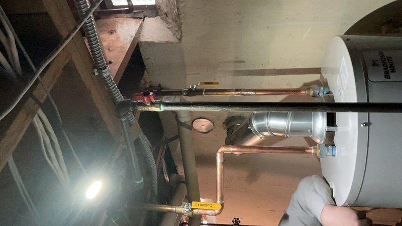 # Job Description

Successfully installed a 40-gallon standard capacity tanked water heater in the mechanical room. The installation included connecting copper supply lines, installing appropriate shut-off valves with identification tags, and routing metallic flexible venting through the existing ceiling structure to ensure proper exhaust ventilation. All plumbing connections were secured and tested, with the unit positioned on the concrete floor and properly integrated into the building's existing utility infrastructure.