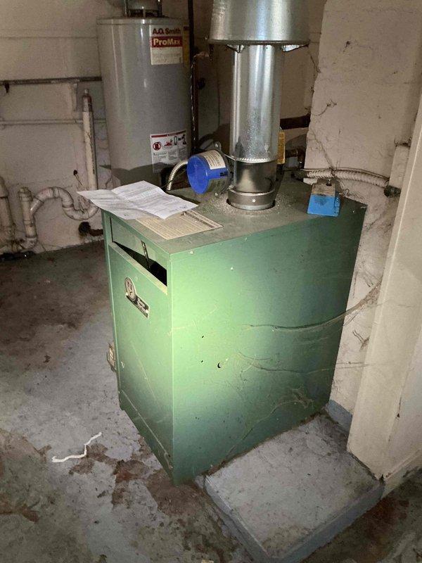 # Job Description

Responded to service call for 20-year-old residential boiler system requiring backflow preventer installation and boiler draining service. Upon arrival, inspected existing hydronic heating system located in basement utility area. System consisted of older green boiler unit with associated circulation pump and copper piping distribution network showing significant age-related patina and oxidation.

Performed complete boiler drain-down procedure to facilitate backflow preventer installation and system maintenance. Shut down boiler and allowed adequate cooling time. Isolated system and drained water from boiler and associated piping through existing drain valves. Inspected circulation pump during drain-down process and confirmed operational condition despite visible age-related wear on exterior housing.

Installed code-compliant backflow preventer on water supply line to boiler system per local plumbing requirements. Made necessary connections to existing copper supply 