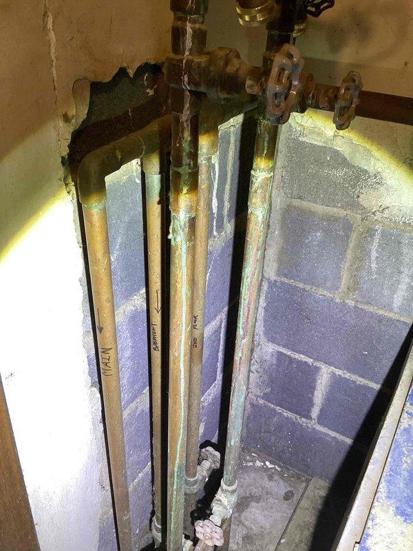 # HVAC Estimate - Boiler Replacement

Completed comprehensive assessment of failing residential boiler system located in basement. Primary issue identified was active leak from boiler unit with equipment age exceeding 10 years, warranting full replacement rather than repair.

Documented existing hydronic heating system configuration including aged copper distribution piping displaying significant corrosion and oxidation throughout. Multiple supply lines with shut-off valves showed green patina formation and surface degradation consistent with extended service life. Evaluated current piping layout and identified need for hydronic piping relocation under floor as part of replacement scope.

Photographed electrical panel configuration and existing plumbing infrastructure to support estimate preparation. Assessed mounting locations, clearances, and utility connections required for new boiler installation. Reviewed basement access, working space availability, and structural considerations f