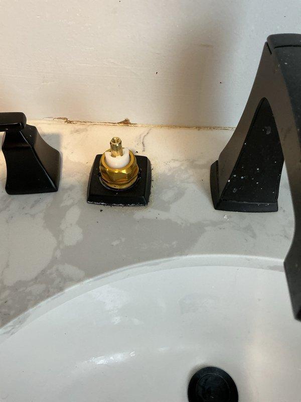 # Plumbing Service Report - Faucet Repair

Responded to service call for loose Delta faucet handle on hot water side. Upon inspection, found the hot water handle mounting hardware had become loose at the deck plate connection, causing significant movement in the fixture while maintaining water-tight integrity with no active leaks present. Disassembled the three-hole widespread faucet configuration, exposing the valve cartridge and mounting assembly. Tightened the mounting hardware and valve connections to manufacturer specifications, secured the deck plate escutcheon, and reassembled all components. Tested both hot and cold water handles for proper operation and confirmed stable mounting with no movement or play in the fixtures.