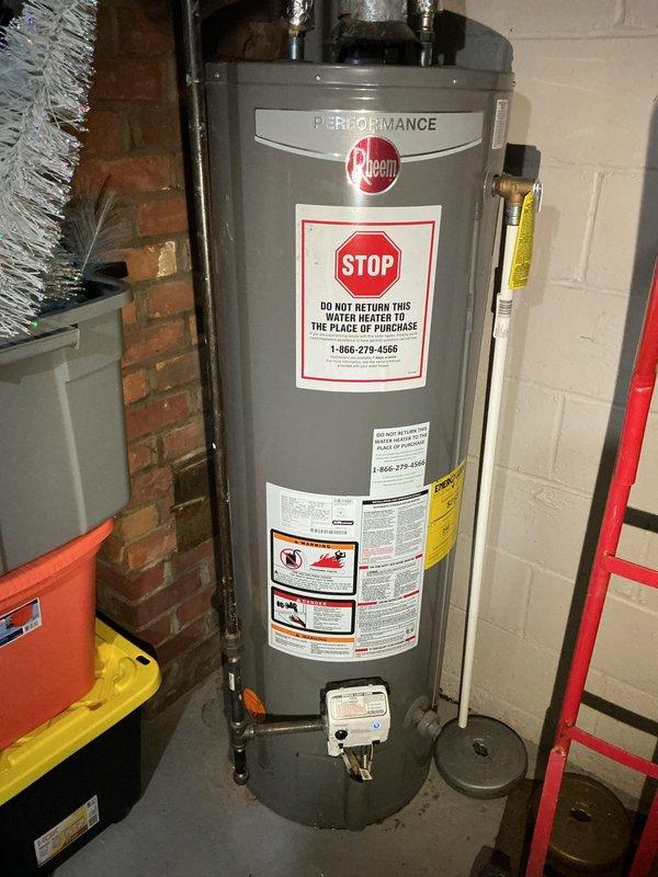 # Plumbing Service Report - Water Heater Replacement

Responded to service call for leaking water heater in basement. Upon arrival, confirmed active leak originating from tank area. Performed visual inspection of existing unit and surrounding plumbing connections to identify source of failure.

Shut off water supply and drained existing water heater to prevent further water damage. Disconnected inlet and outlet copper piping, temperature and pressure relief valve discharge line, and gas supply connection. Removed failed unit from service location.

Installed new Rheem Performance tankless water heater as replacement. Positioned unit against concrete block wall in same location as previous heater. Connected cold water inlet and hot water outlet lines using existing copper piping infrastructure. Installed new temperature and pressure relief valve with proper discharge piping. Reconnected gas supply line with appropriate fittings and verified connections for safety.

Mounted expansion tan