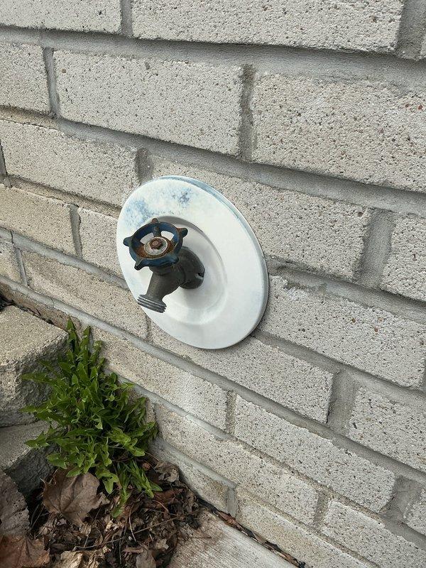 # Service Report: Water Leak Repair

Responded to service call for leaking outdoor spigot in garage with ruptured supply pipe causing water spray during operation. Upon inspection, identified severely corroded copper supply line with compromised elbow joint showing advanced oxidation and deterioration. The failed connection point was actively leaking when pressurized, with evidence of long-term moisture damage visible on adjacent wooden structural support, indicated by dark vertical staining and discoloration.

Replaced defective copper pipe section and corroded spigot assembly. Installed new frost-proof sillcock with proper mounting hardware on exterior wall. Verified all connections were secure, tested system under full pressure, and confirmed leak elimination with no further water discharge.