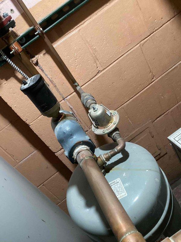 Responded to service call for leaking automatic air vent on residential boiler system approximately 10-15 years old. Upon arrival, inspected boiler and associated components in basement mechanical room. Confirmed active leak at automatic air vent assembly. Assessed condition of existing copper piping, expansion tank, circulator pump, and exhaust venting system. Removed failed automatic air vent from boiler piping. Installed replacement automatic air vent with proper thread sealant and torque specifications. Verified proper operation of new air vent and checked for leaks. Tested boiler system operation and confirmed all components functioning correctly with no active leaks present upon departure.