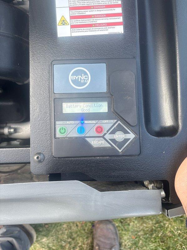 Performed routine maintenance on a 16KW Honeywell standby generator. Inspected air filter, fuel delivery system components, and control panel functionality. Verified SYNC 2.0 controller display showing proper battery condition, confirmed AUTO/MANUAL selector operation, and documented all safety systems operational with unit running normally.