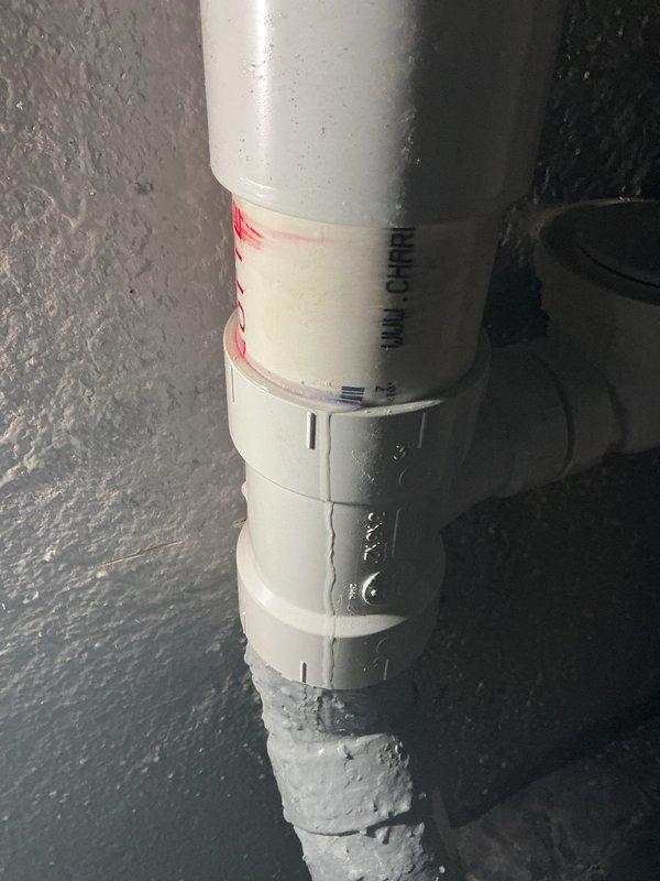 Responded to callback for ongoing water leak at previously repaired PVC drainage piping. Upon inspection, identified active leak at vertical pipe coupling joint where recent repair had been attempted. Disassembled existing coupling connection, cleaned and prepped pipe surfaces, and reinstalled joint using proper PVC primer and cement application techniques to ensure watertight seal. Verified all connections were secure and tested system for proper drainage and leak elimination.