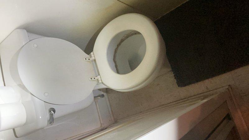 Responded to service call for excessively running toilet in main level bathroom off garage in approximately 40-year-old home. Upon arrival, assessed existing toilet and confirmed constant running condition due to worn internal components. Per customer request, proceeded with complete toilet replacement rather than repair of aging fixture. 

Shut off water supply at existing valve and disconnected water supply line from tank. Removed toilet mounting bolts and lifted old toilet from floor flange. Scraped old wax ring residue from floor flange and inspected flange condition for proper seal compatibility. Cleaned mounting area thoroughly to ensure proper installation surface.

Installed new wax ring onto floor flange and carefully positioned new white ceramic toilet onto flange, aligning mounting holes. Secured toilet to floor with new brass closet bolts and washers, torquing evenly to prevent rocking while avoiding over-tightening that could crack porcelain base. Verified toilet was level