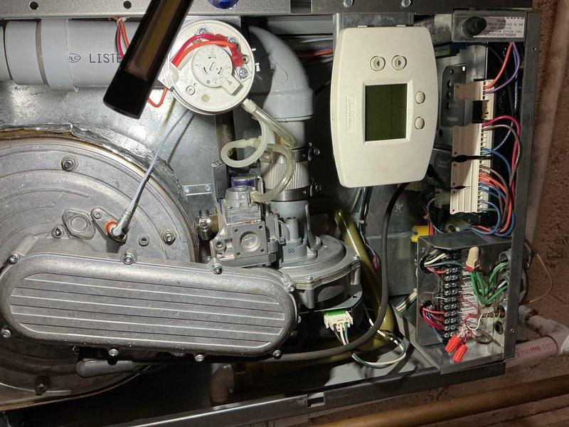 Responded to callback for no heat condition on boiler system in apartment above garage. Customer reported thermostat set to 65°F with no heat output, requiring use of space heaters. Upon inspection, identified multiple failed components requiring replacement: control board, pressure relief valve, air vent, and expansion tank. Documented system conditions with photos showing aged copper piping, pressure gauge assembly, blower motor housing, capacitor, and digital control unit with associated wiring. Ordered necessary parts including expansion tank for pickup and arranged for control board, pressure relief valve, and air vent delivery to shop for installation upon arrival.