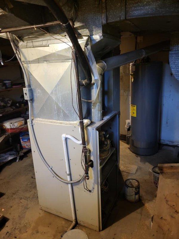 Conducted comprehensive assessment of 20-year-old residential HVAC system located in basement for equipment replacement estimate. Evaluated existing furnace unit with white metal cabinet, associated PVC condensate piping, flexible conduit connections, and exhaust flue system. Inspected air conditioning system components and existing ductwork configuration, noting 20x54 supply trunk dimensions. Documented current equipment conditions, installation layout, and mechanical room environment through photographic survey. Provided detailed replacement options and recommendations for complete heating and cooling system upgrade to improve efficiency and reliability.