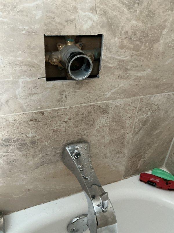 # Bathtub Drain Assembly Replacement

Responded to a bathroom drain issue that had been ongoing for 30 days in a 60-year-old residential property. Upon arrival, conducted a thorough inspection of the bathtub drainage system to identify the source of the clog and poor drainage performance.

## Work Performed

Removed the existing bathtub drain assembly, which showed significant age-related deterioration and corrosion consistent with the home's age. The original brass drain flange and internal components exhibited heavy buildup and wear that was impeding proper water flow. 

Created an access point in the bathroom wall to reach the drain assembly's connection points and associated plumbing. This wall opening allowed for proper removal and replacement of the corroded drain components that could not be accessed from the tub side alone.

Extracted the old drain flange, stopper mechanism, and associated hardware. The removed parts displayed extensive mineral deposits and corrosion that had a