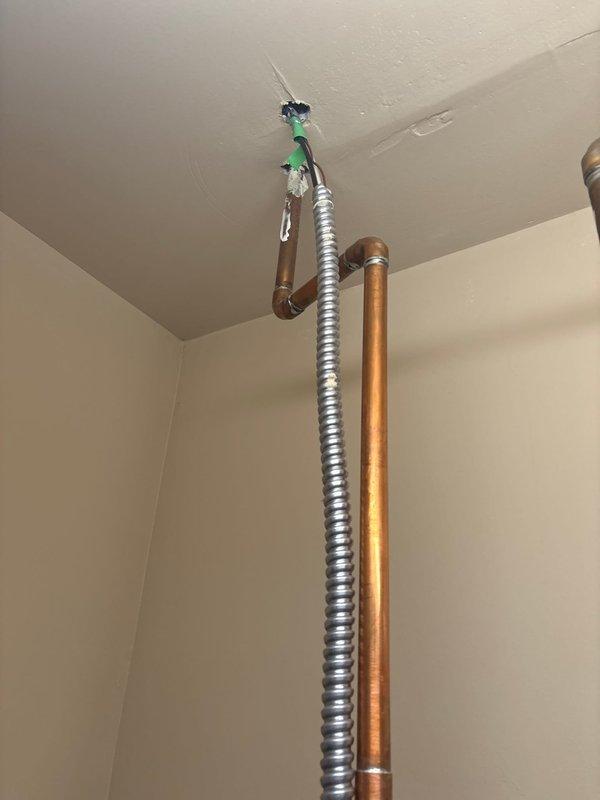 Responded to City of Royal Oak electrical code violation by installing proper protection for non-metallic cable and adding missing bushing to greenfield conduit termination. Corrected flexible metal conduit installation at ceiling junction point where greenfield was previously terminated without required insulated throat bushing, ensuring compliance with NEC requirements for conductor protection. All work completed to municipal code standards and documented with photographic evidence.