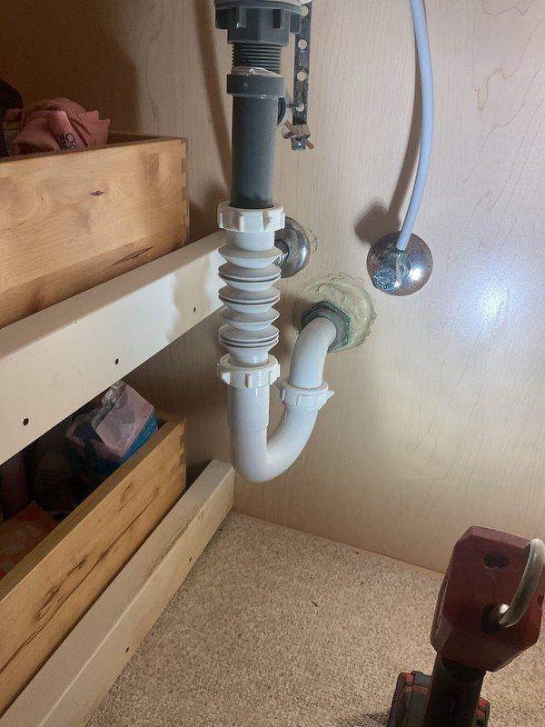 Responded to a bathroom sink drain emergency involving a cracked PVC elbow fitting in the P-trap assembly beneath the vanity. Upon inspection, identified a failed connection point in the white PVC drain configuration that required immediate replacement to prevent water damage. Removed the compromised elbow section, installed a new PVC fitting with proper sealing, and verified all connections in the P-trap assembly for secure operation and proper drainage flow.