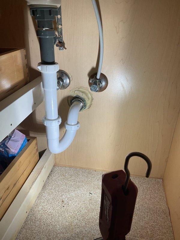 Responded to a bathroom sink drain emergency involving a cracked PVC elbow fitting in the P-trap assembly beneath the vanity. Upon inspection, identified a failed connection point in the white PVC drain configuration that required immediate replacement to prevent water damage. Removed the compromised elbow section, installed a new PVC fitting with proper sealing, and verified all connections in the P-trap assembly for secure operation and proper drainage flow.