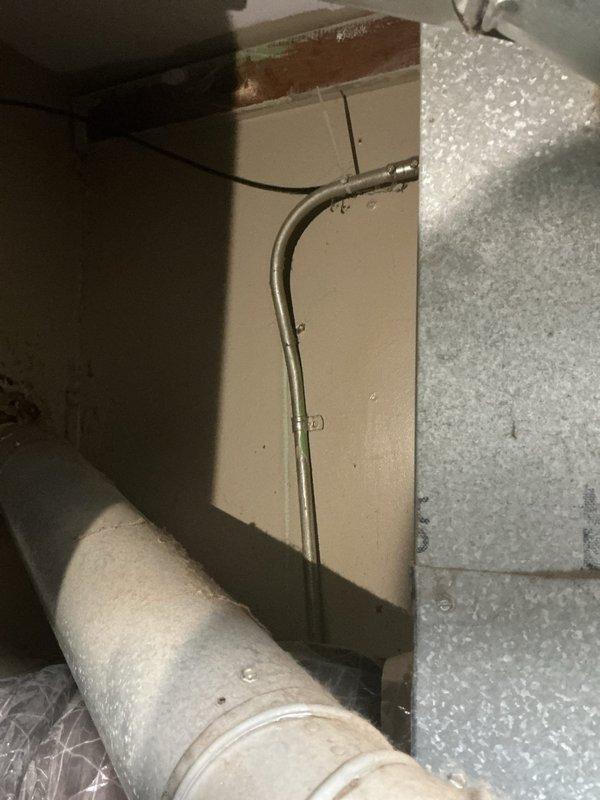 Responded to complaint of burning smell originating from tanked water heater in first-floor kitchen utility closet. Upon arrival, conducted thorough inspection of water heater unit and surrounding mechanical equipment including adjacent furnace system. Examined water heater exterior, connections, venting system, and associated copper piping for signs of overheating, electrical issues, or mechanical failure. Inspected flue pipe configuration and draft hood assembly for proper venting and potential backdraft conditions. Verified gas connections, burner assembly access, and surrounding insulation materials for heat damage or deterioration. Documented equipment condition with photographs showing water heater placement in compact closet space alongside HVAC equipment. No immediate safety hazards identified requiring emergency shutdown during inspection period.