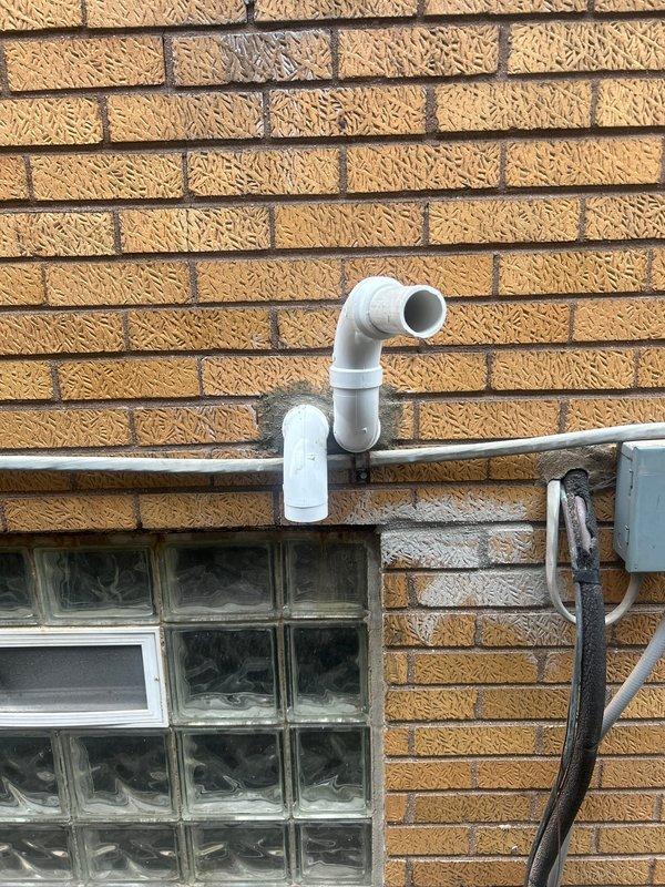 Completed installation of 70,000 BTU furnace system including mechanical and electrical connections, liner installation, and reconnection of existing components. Obtained required mechanical and electrical permits prior to installation, and system qualified for utility rebate program. Exterior venting and electrical work completed with proper PVC pipe configuration and conduit installation visible on building exterior.