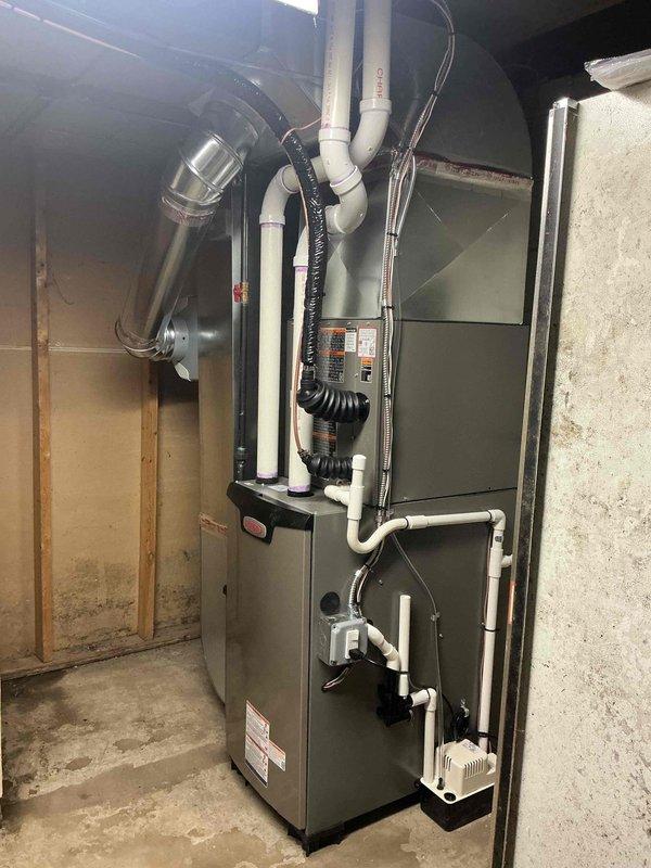 Completed full HVAC system installation including a 70,000 BTU furnace, 2-ton rear-discharge air conditioning unit, programmable thermostat, whole-home humidifier, and condensate pump in residential basement location. Installed all necessary PVC venting for high-efficiency furnace exhaust and intake, routed metallic supply ductwork, and secured condensate drainage lines with proper support. Reconnected all electrical connections, verified proper system operation, and ensured installation met mechanical permit requirements. System registered under AHRI certificate 215566314 and qualified for utility rebate program.