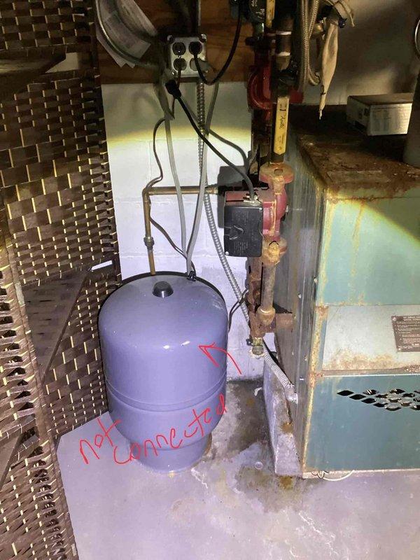 Conducted comprehensive assessment of residential boiler system exceeding 75 years of service life in basement mechanical room. Documented existing Peerless brand unit showing significant age-related deterioration, including extensive surface corrosion, rust streaking on cabinet panels, and compromised structural integrity of metal casing. Noted disconnected expansion tank with visible markings indicating non-operational status, along with aged copper piping exhibiting oxidation and outdated electrical connections requiring replacement. Provided detailed photographic documentation and recommended complete boiler system replacement due to equipment age, safety concerns, and inefficiency of existing installation.