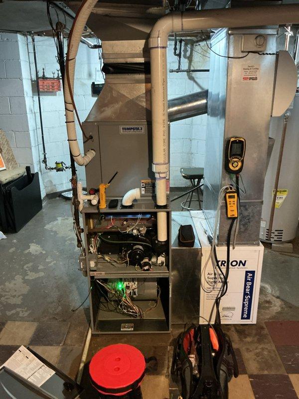 Performed complimentary furnace inspection on Tempstar unit located in basement mechanical room. Inspected humidifier feed tube orifice as requested and identified leaking water pump on 10-year-old humidifier assembly. System remains operational with heating and cooling functions unaffected. Documented equipment condition with photos showing active burner operation and internal components. Recommended humidifier pump replacement to prevent further water leakage.