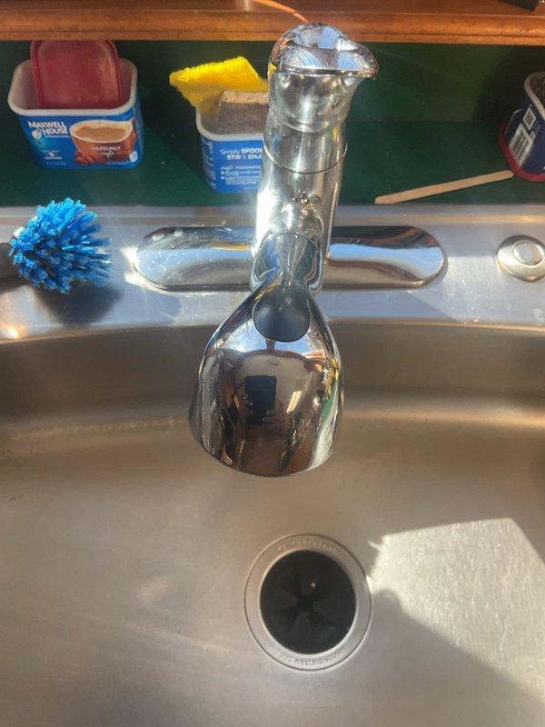 Completed installation of customer-supplied Moen kitchen faucet in main floor kitchen of 35-year-old home. Removed existing chrome faucet and installed new stainless steel faucet with tall spout and side spray attachment. Connected supply lines to existing shut-off valves under sink, verified proper water flow and pressure, and tested for leaks. All connections secure and functioning properly upon completion.
