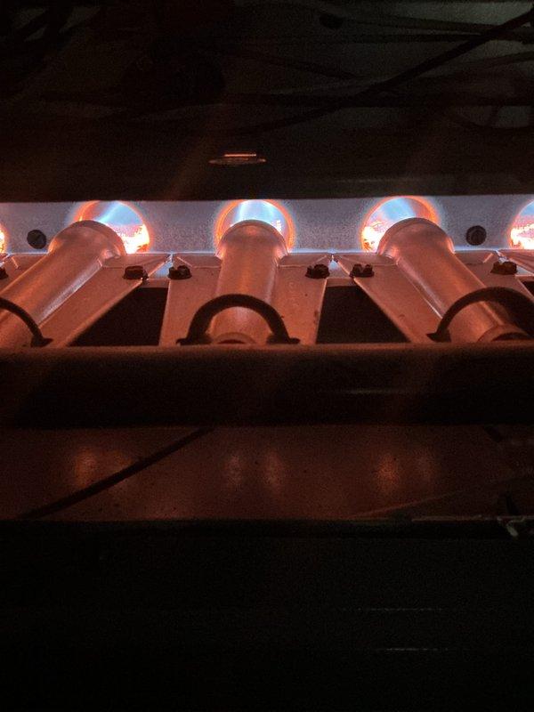 Completed comprehensive gold-level furnace inspection on a 4-year-old Daikin unit located in the basement. Performed full system evaluation including visual inspection of heat exchanger, burner assembly, and venting components. Verified proper ignition sequence and observed clean, even flame pattern across all four burners with appropriate blue flame characteristics indicating optimal combustion. Inspected blower motor operation, checked air filter condition, and examined all electrical connections for safety and proper function. Tested thermostat communication and confirmed system cycling properly. Documented equipment condition with photographs showing furnace installation, ductwork connections, and active burner operation. All components operating within manufacturer specifications with no immediate service needs identified.