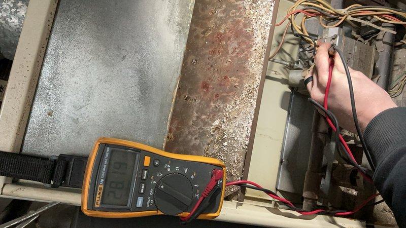 Responded to service call for furnace with pilot ignition failure on unit over 20 years old located in furnace closet. Performed diagnostic testing using multimeter to check electrical components and circuits. Found significant corrosion on access panel and interior components, with heavy dust accumulation throughout system affecting operation. Tested blower motor assembly, heat exchanger, and burner assembly connections. Identified failed ignition system components preventing pilot from lighting. Unit showed advanced age-related deterioration with moisture damage and oxidation on metal surfaces. Recommended replacement due to extensive corrosion, failed ignition components, and overall system condition exceeding serviceable lifespan.