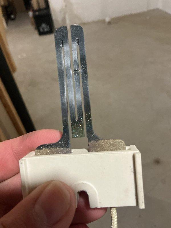 # No Heat Service Call - 10+ Year Old Unit

Responded to no heat call on aging HVAC system. Upon inspection, identified heavily corroded heating element with significant oxidation and mineral buildup on metal prongs, preventing proper electrical connection and heat generation. Removed failed component and verified burner assembly operation. Replaced corroded heating element with new part, restored power to unit, and confirmed proper ignition sequence with visible blue flame at burners. Tested system through complete heating cycle to verify restoration of heat output and safe operation. Unit returned to normal heating function.