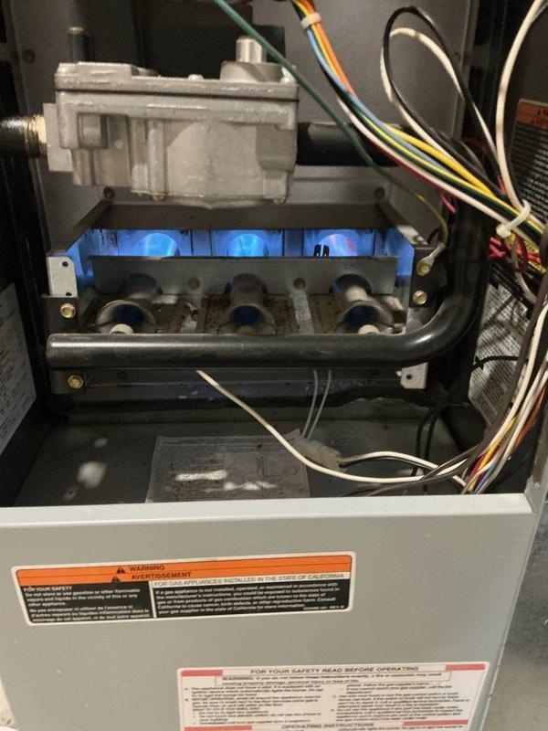 # No Heat Service Call - 10+ Year Old Unit

Responded to no heat call on aging HVAC system. Upon inspection, identified heavily corroded heating element with significant oxidation and mineral buildup on metal prongs, preventing proper electrical connection and heat generation. Removed failed component and verified burner assembly operation. Replaced corroded heating element with new part, restored power to unit, and confirmed proper ignition sequence with visible blue flame at burners. Tested system through complete heating cycle to verify restoration of heat output and safe operation. Unit returned to normal heating function.