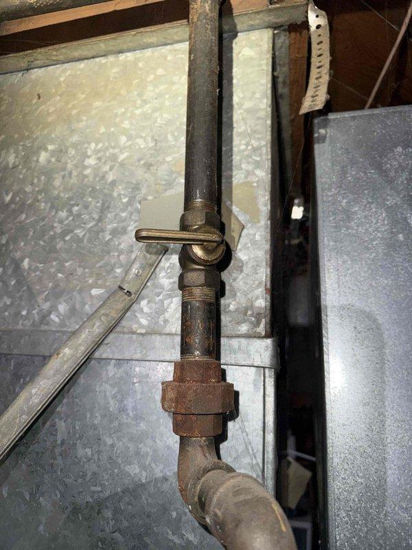 Responded to no heat call on 20-year-old furnace located in basement. Upon arrival, confirmed thermostat had power and was functioning properly, but unit was not coming on. Performed diagnostic inspection and documented existing conditions. Found heavily corroded gas piping with significant rust and oxidation on brass fittings and unions, indicating advanced age and deterioration of fuel supply components. Inspected ductwork and observed aged infrastructure consistent with unit age. Photographed corroded pipe assembly, elbow joints, and surrounding mechanical systems for documentation purposes. Advised customer of findings regarding aged equipment and deteriorated gas piping requiring attention for safe operation.