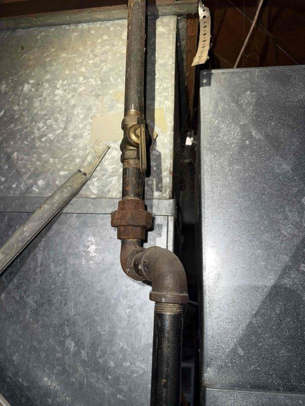Responded to no heat call on 20-year-old furnace located in basement. Upon arrival, confirmed thermostat had power and was functioning properly, but unit was not coming on. Performed diagnostic inspection and documented existing conditions. Found heavily corroded gas piping with significant rust and oxidation on brass fittings and unions, indicating advanced age and deterioration of fuel supply components. Inspected ductwork and observed aged infrastructure consistent with unit age. Photographed corroded pipe assembly, elbow joints, and surrounding mechanical systems for documentation purposes. Advised customer of findings regarding aged equipment and deteriorated gas piping requiring attention for safe operation.