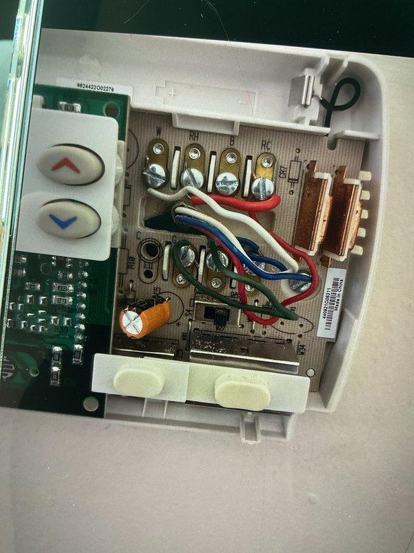 Responded to service call for thermostat malfunction causing air conditioning to activate when heating was called for, along with water leaking from exhaust PVC on less than one-year-old system. Inspected control board and thermostat wiring connections, documented existing wire terminations at both the air handler control board and thermostat interface. Found improper thermostat configuration causing incorrect system staging between heating and cooling modes. Verified all wire connections at terminal blocks were secure, checked capacitor and control board for signs of moisture damage or corrosion related to reported PVC leak. Photographed control board layout and wiring configuration for warranty documentation purposes. System remained operational throughout inspection. Advised that thermostat programming requires correction to resolve heating/cooling crossover issue, and PVC condensate drain requires further evaluation to identify source of water leak and prevent future moisture intru