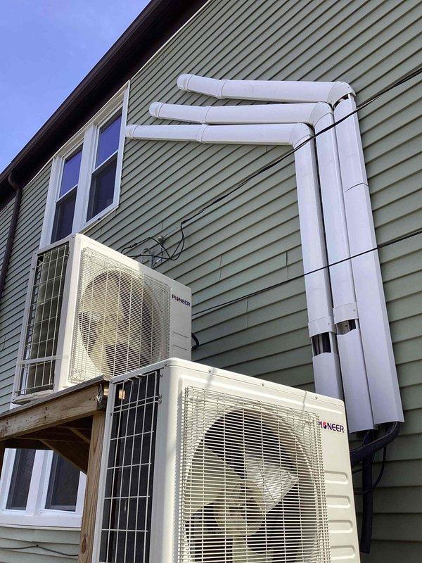 Performed estimate for residential ductless mini-split heat pump system with two units installed by non-professional, resulting in code violations and equipment failure. Assessed lower unit with suspected compressor failure as priority for replacement, while upper unit remains operational. Documented Pioneer brand outdoor condensers mounted on exterior wall with interconnecting refrigerant lines and drainage piping, identifying 3-year-old and less-than-1-year-old systems requiring remediation to meet code compliance.