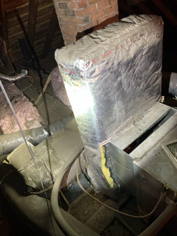 Conducted estimate for complete air conditioning system replacement at residential single-family home. Inspected existing 10-year-old system components located in attic space, including air handler unit, ductwork configuration, and plenum connections. Documented current installation featuring insulated flex duct runs, vertical supply plenum with reflective wrap insulation, and existing support structure. Evaluated attic access conditions, workspace constraints, and structural framing for new equipment installation. Photographed existing HVAC infrastructure including duct connections, insulation materials, and equipment positioning to assess replacement requirements and determine proper sizing for new system components.