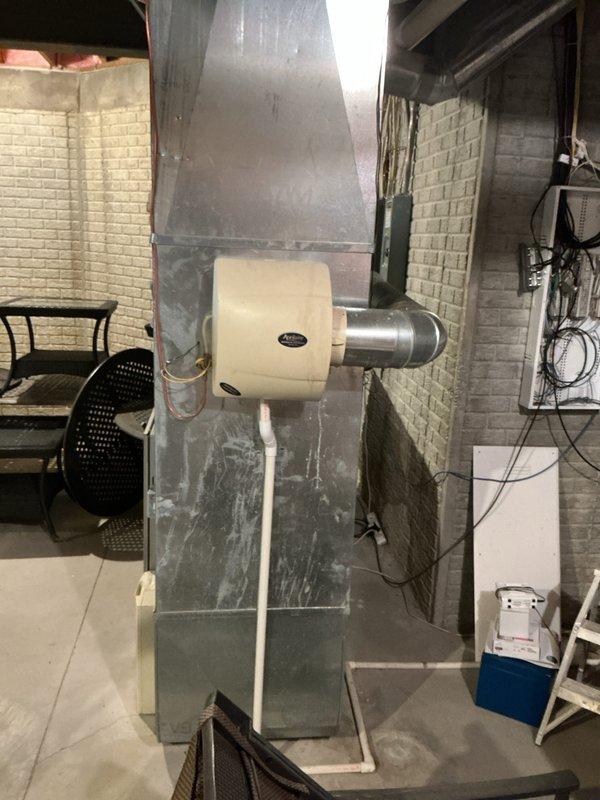 Responded to lower level heating complaint where thermostat was set to 71 degrees but temperature would not rise above 65-67 degrees. Evaluated 3-4 year old furnace system located in basement with White-Rodgers thermostat and humidifier attachment. Diagnosed failed secondary heat exchanger and tripped rollout limit switch on the unit. Provided estimate for complete furnace replacement and optional air conditioning system upgrade due to age and condition of existing equipment requiring major component replacement.