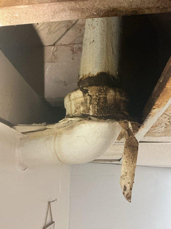 Responded to service call for toilet leak in master bedroom causing water damage to basement below. Upon inspection, identified failed wax ring seal at toilet flange connection allowing wastewater to seep through floor assembly into lower level. Examined basement ceiling plumbing assembly and confirmed active leak originating from toilet drain connection. Observed corroded brass closet flange fittings and aged metal drain components contributing to seal failure. Removed toilet from floor, scraped old wax ring residue from flange and toilet horn, and inspected flange for structural integrity. Replaced wax ring with new reinforced seal and reinstalled toilet with proper alignment and secure bolting to flange. Reconnected water supply line and tested flush cycles for proper drainage and seal integrity. Verified no leakage at base during multiple flush tests. Inspected basement area beneath repair location and confirmed cessation of active leak. Advised homeowner regarding previously noted