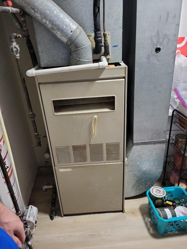 Completed comprehensive assessment of 10+ year old natural gas furnace and air conditioning system located in basement for replacement estimate. Both units currently operational but customer seeking replacement due to inefficiency concerns. Evaluated existing beige furnace unit with aged ductwork, associated gas lines, and AC system including overhead duct configuration and refrigerant lines. Documented equipment condition showing visible wear, surface discoloration, and dust accumulation throughout mechanical components. Provided detailed estimates for complete furnace and AC replacement system under quotes 07678-01 and 07678-03.