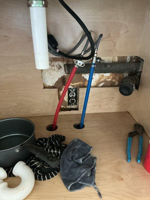 Responded to a partially clogged kitchen sink drain in a 1960s single-family home where water was draining slowly and backing up after initial flow. Accessed the drain system through the cabinet beneath the sink and inspected the P-trap and drain pipe assembly. Removed the existing P-trap components and cleared accumulated debris and buildup causing the blockage. Verified that other household drains were functioning properly, confirming the clog was isolated to the kitchen sink line. Reassembled the drain system with proper connections, tested water flow to ensure complete drainage without backup, and confirmed the issue was fully resolved. Left work area clean with all plumbing fixtures operating normally.