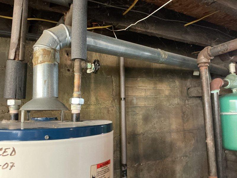 Responded to emergency call for leaking hot water tank in basement with water discharge from bottom of unit. Upon inspection, determined tank had failed and required complete replacement due to irreparable leak at base. Disconnected and removed existing failed water heater, including all supply lines, discharge piping, and electrical connections. Installed new tanked water heater with proper venting, connected hot and cold water supply lines with appropriate shut-off valves, and installed temperature and pressure relief valve with proper discharge piping termination. Reconnected all plumbing connections using code-compliant materials and methods, ensuring proper clearances around unit for maintenance access. Tested all connections for leaks, verified proper water flow and heating operation, and confirmed system functionality before completing installation. Unit now operating within normal parameters with no active leaks detected.