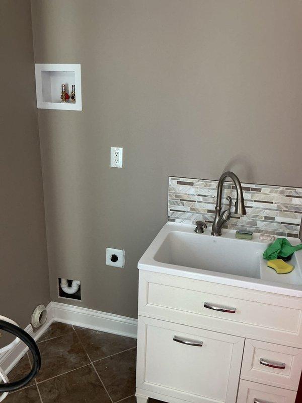 Completed code violation repairs for laundry room and lavatory venting system to bring installation into compliance with current plumbing codes. Installed new electrical junction box for light fixture, properly secured to structural stud framing to meet electrical code requirements. Addressed existing non-compliant electrical box that was inadequately mounted and featured an open cut in the wall surface. All work performed to pass inspection standards.